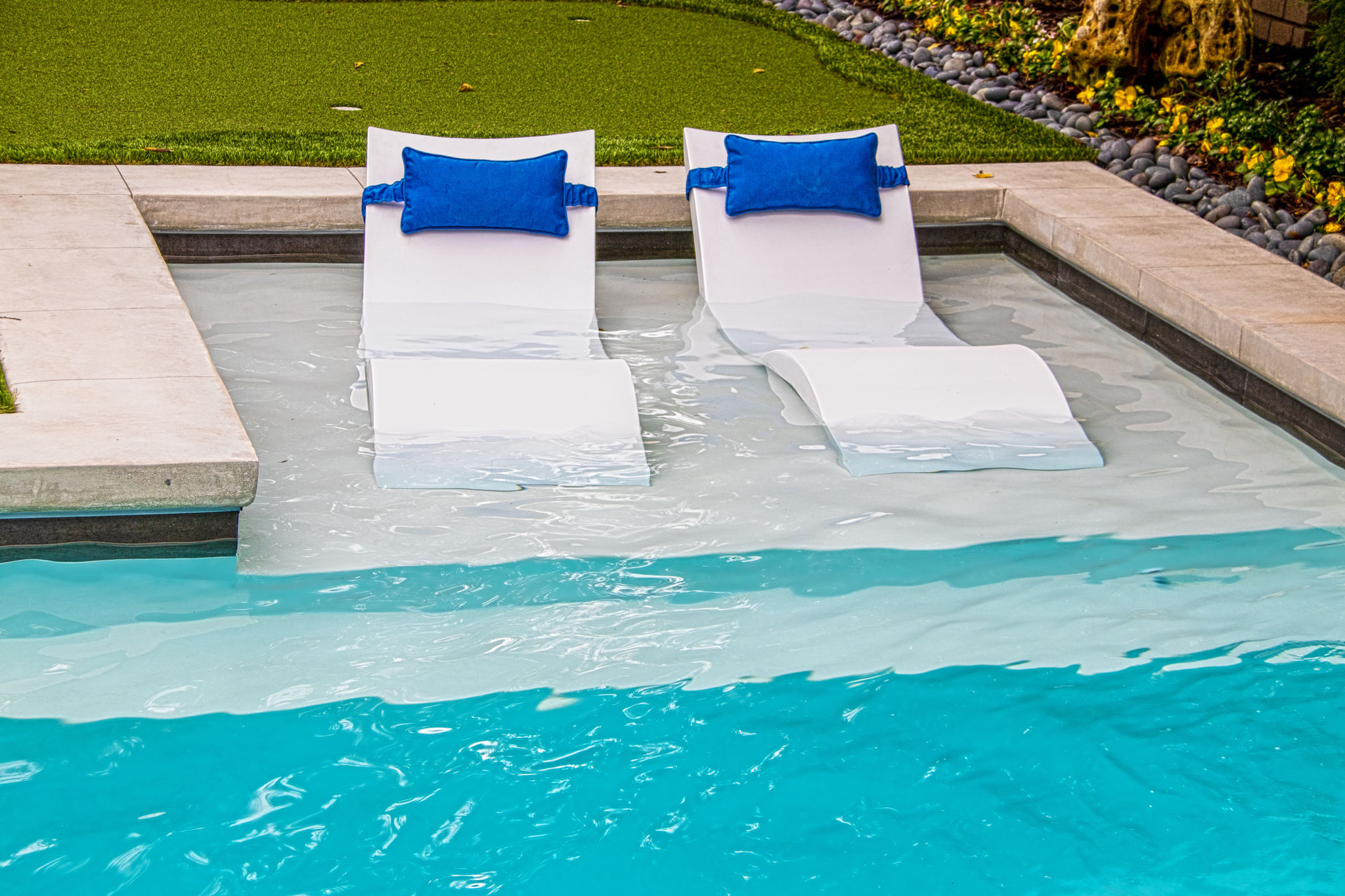 Comfy white Ledge Loungers in shallow end of refreshing blue swimming ...