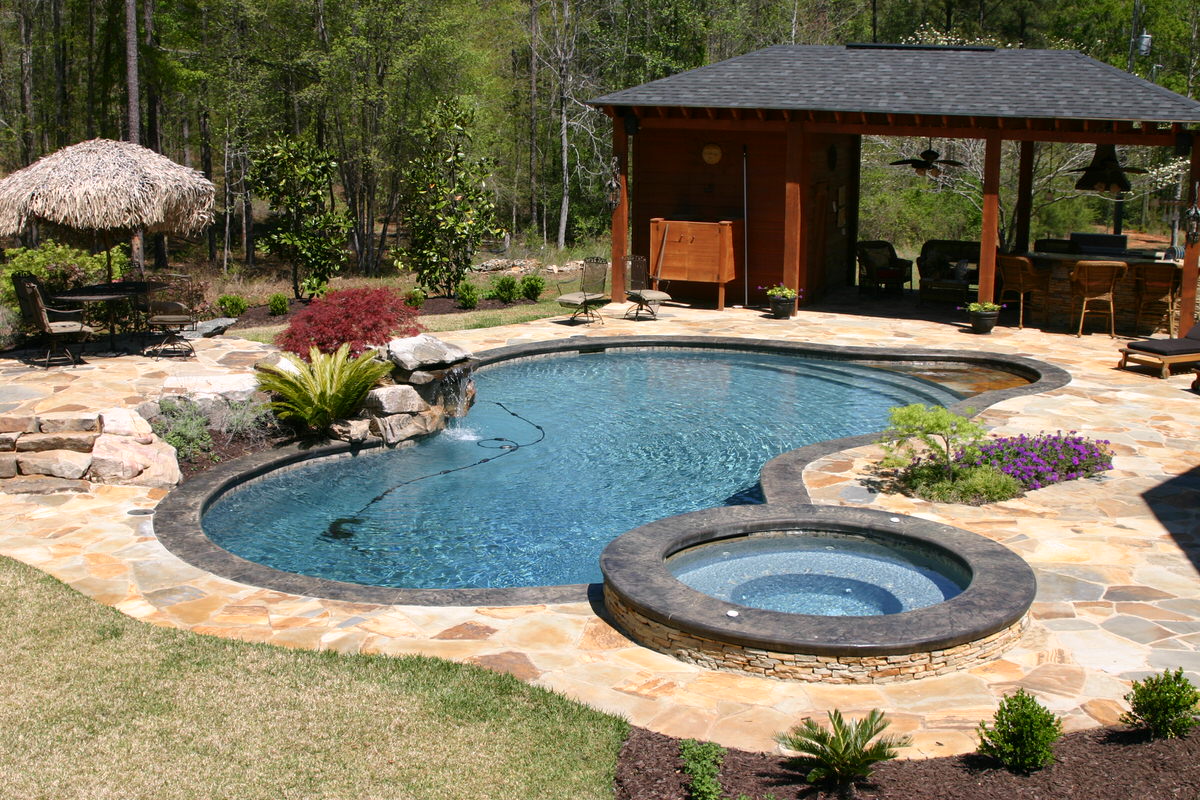 Aerial view of a luxury inground pool with attached spa and lounge chairs — custom pool by Mid State Pools Warner Robins GA