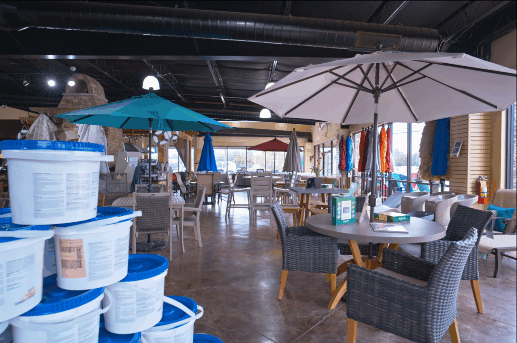Wide shot of a complete conversation set arranged as it would appear on a patio - three comfortable chairs with weather-resistant cushions arranged around a matching dining table.