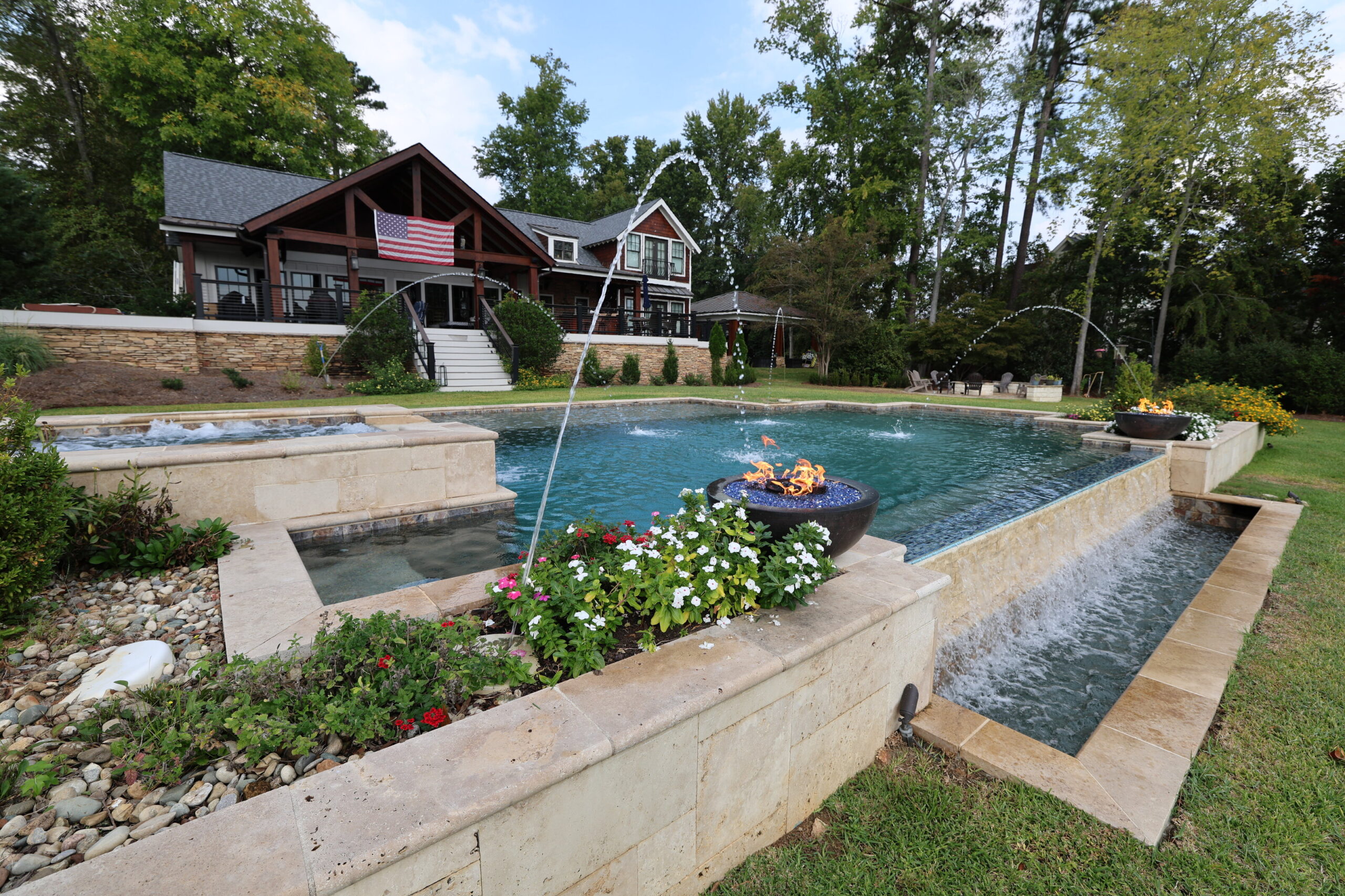 Custom freeform pool with natural landscaping and residential homes visible in background