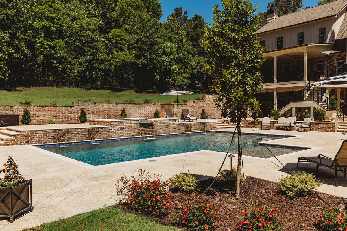 Pool safety features - secure pool fence with self-closing gate and safety equipment protecting family swimming pool
