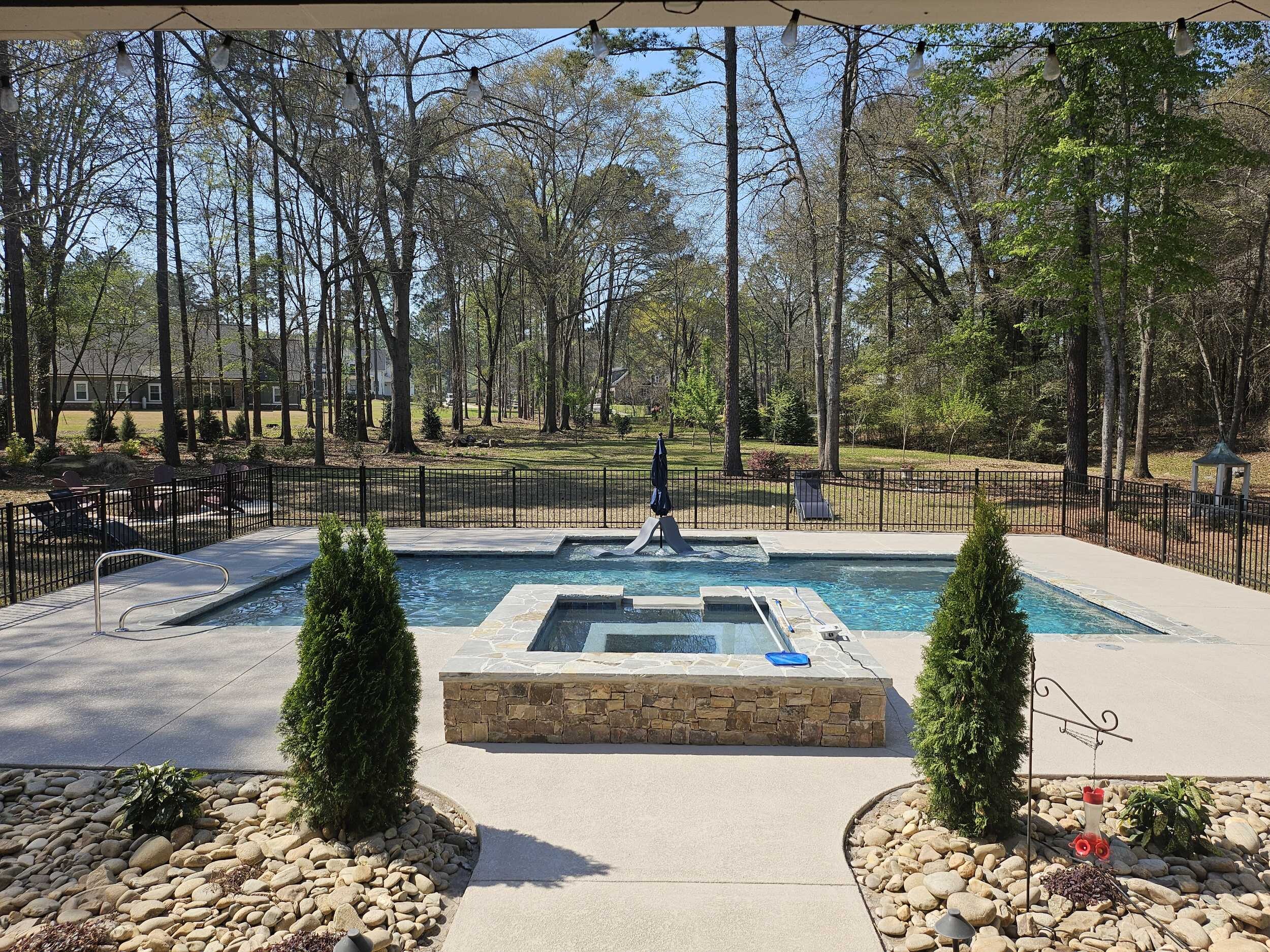 Completed inground swimming pool with decking in a Warner Robins, Georgia backyard