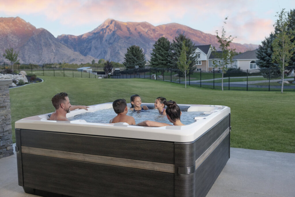 Large family hot tub with parents and children enjoying together, mountain views, multi-generational spa use