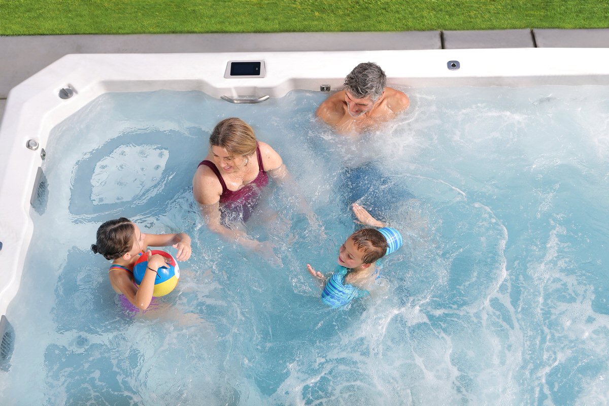 Swim spa with family playing, showing exercise and recreation features, parents and children using current pool
