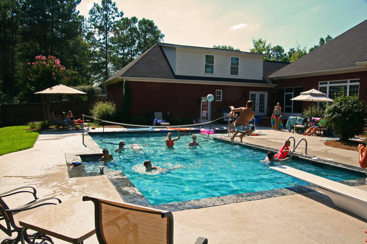 Spring pool opening - family enjoying clean sparkling swimming pool in backyard after professional opening service